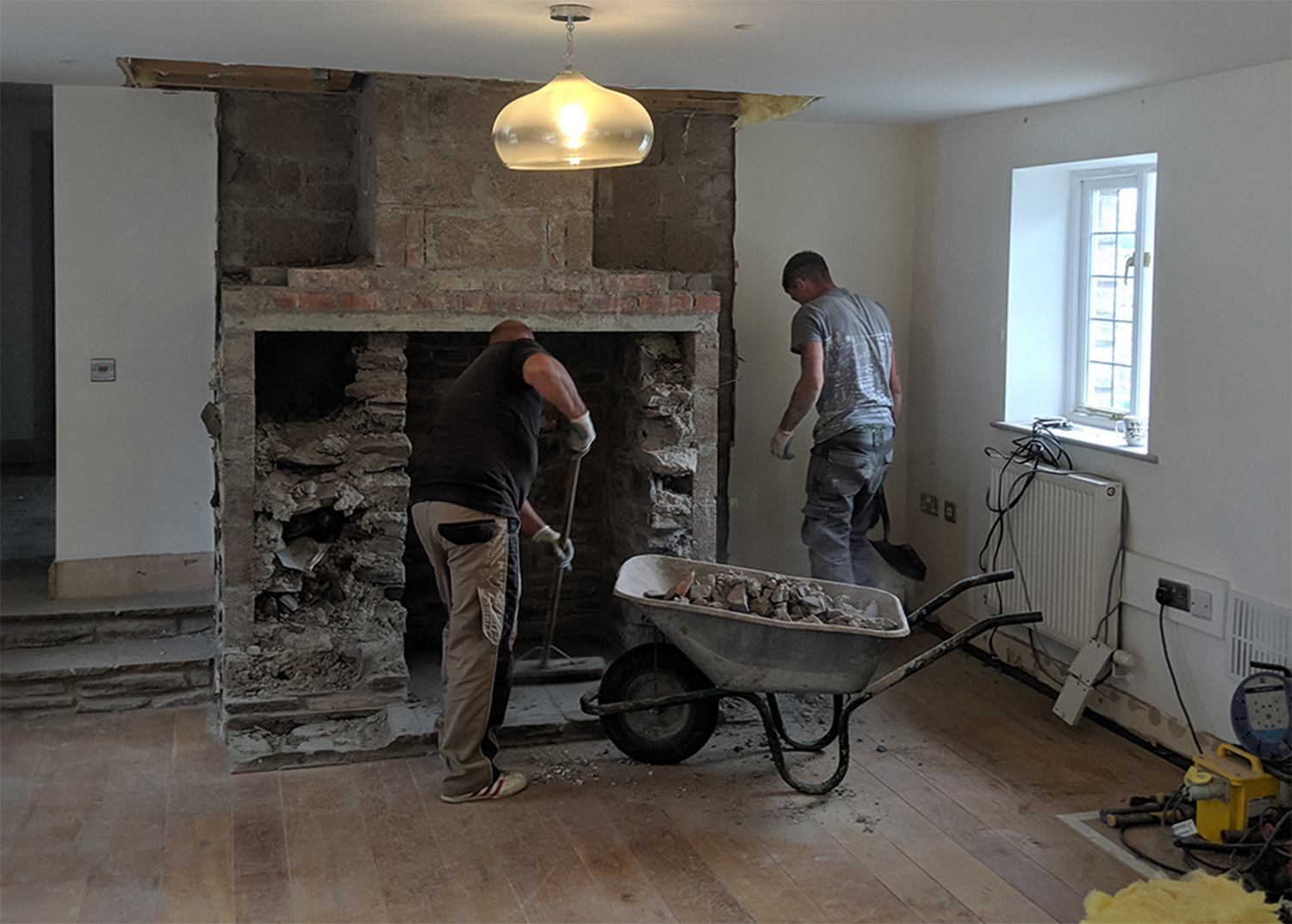 A photo of a chimney being taken out by builders to make way for seating.