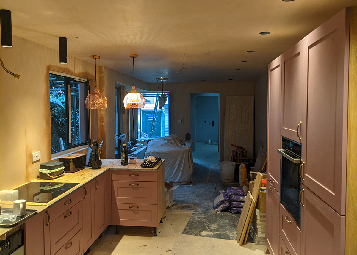 A photo of the same kitchen mid build - the windows are partially in and there is lots of building mess.