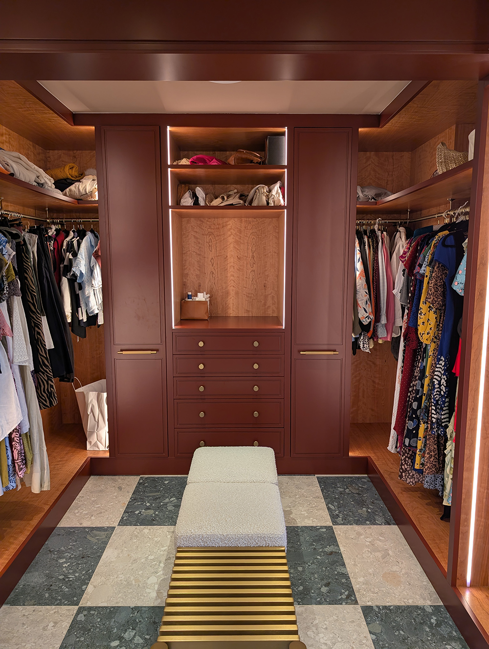 A photo of the finished dressing room with pull out shoe storage on either side of drawers.
