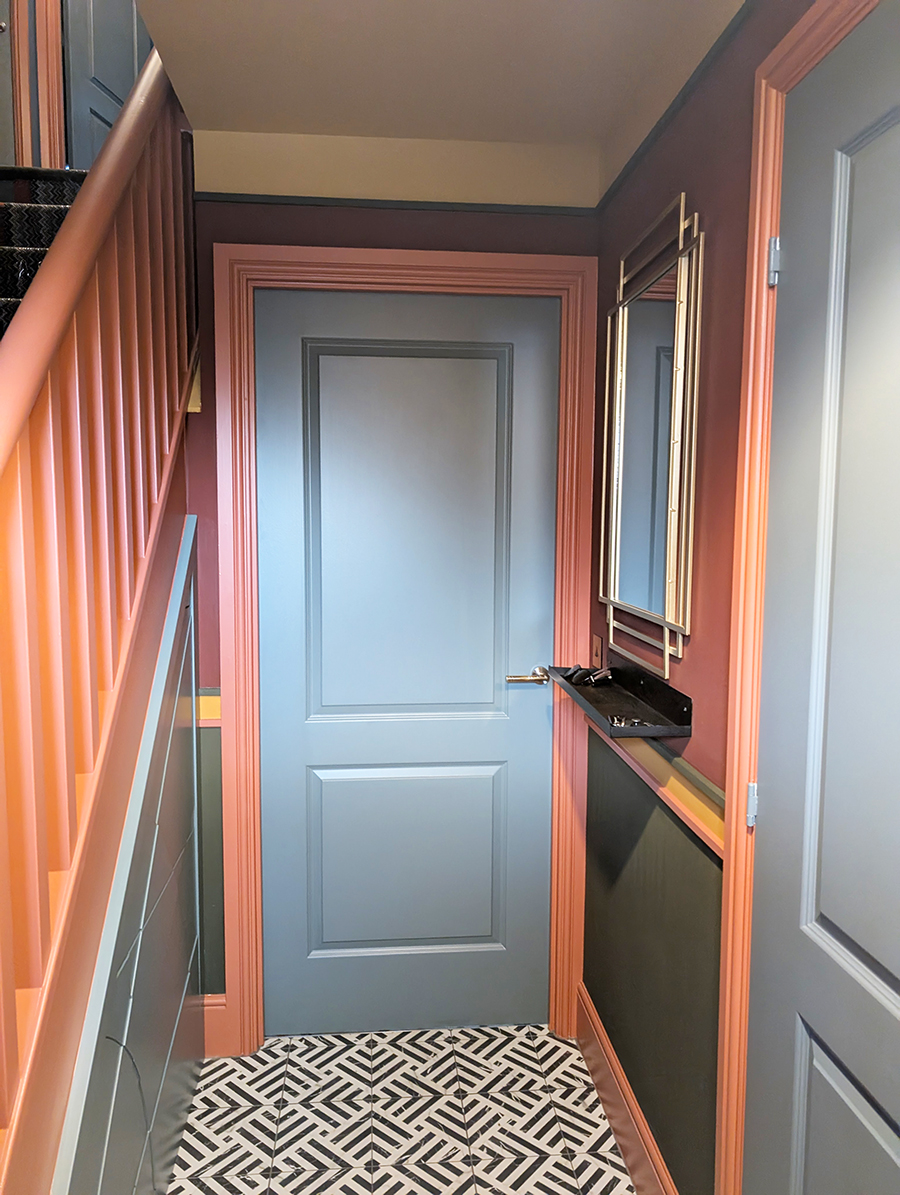 A photo of the finished hallway with a blue door to the kitchen.