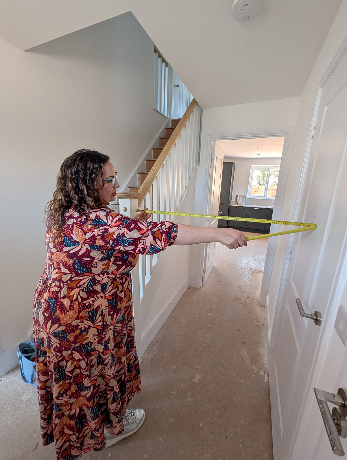 A photo of Louise measuring the hallway space.