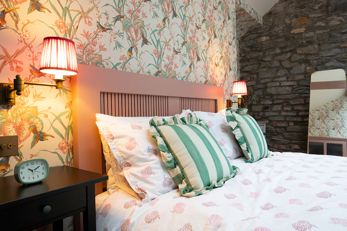 A photo of a berdoom with fabric shades on wall lights by the bed.