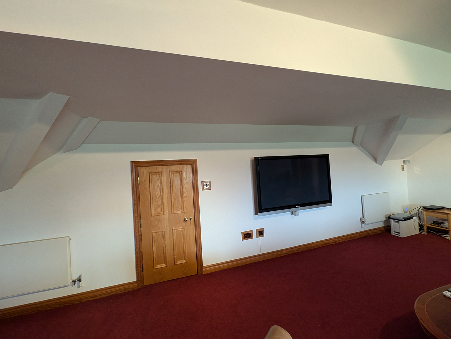 A photo showing the room before work started, with white walls and clutter.