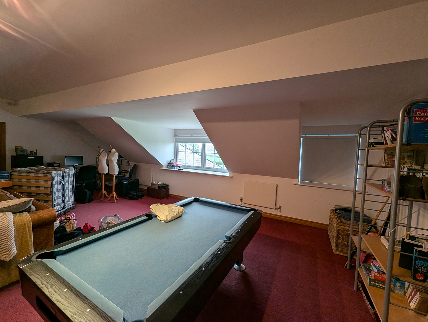 A photo showing the room before work started, with white walls and a red carpet.
