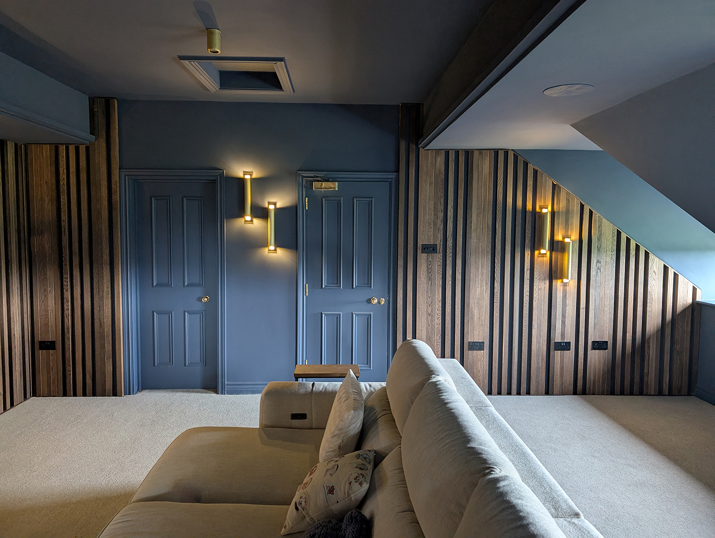 A photo of the cinema room with the brass wall light on.
