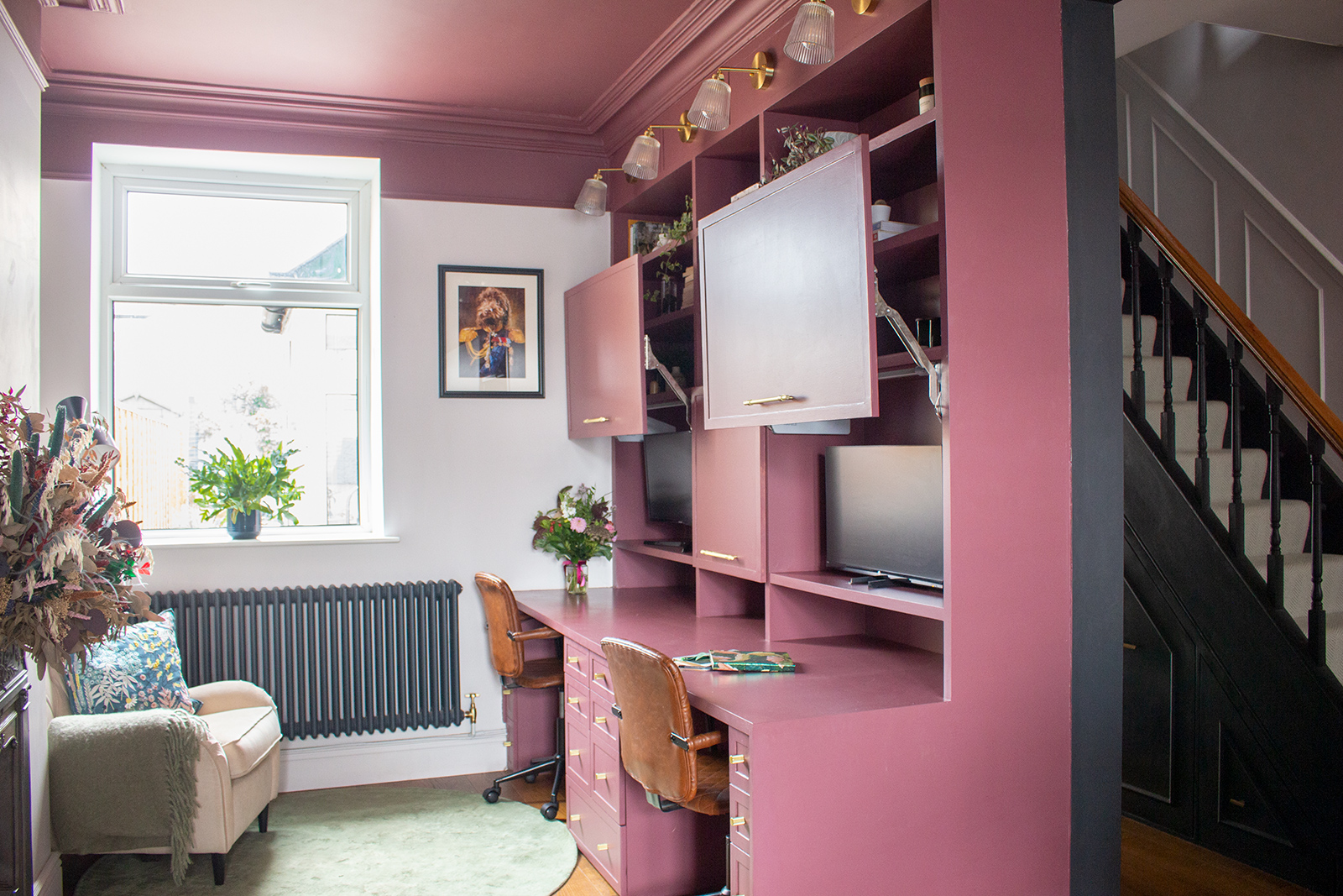 A photo of a dresser style built in desk with the pull up cupboards open.