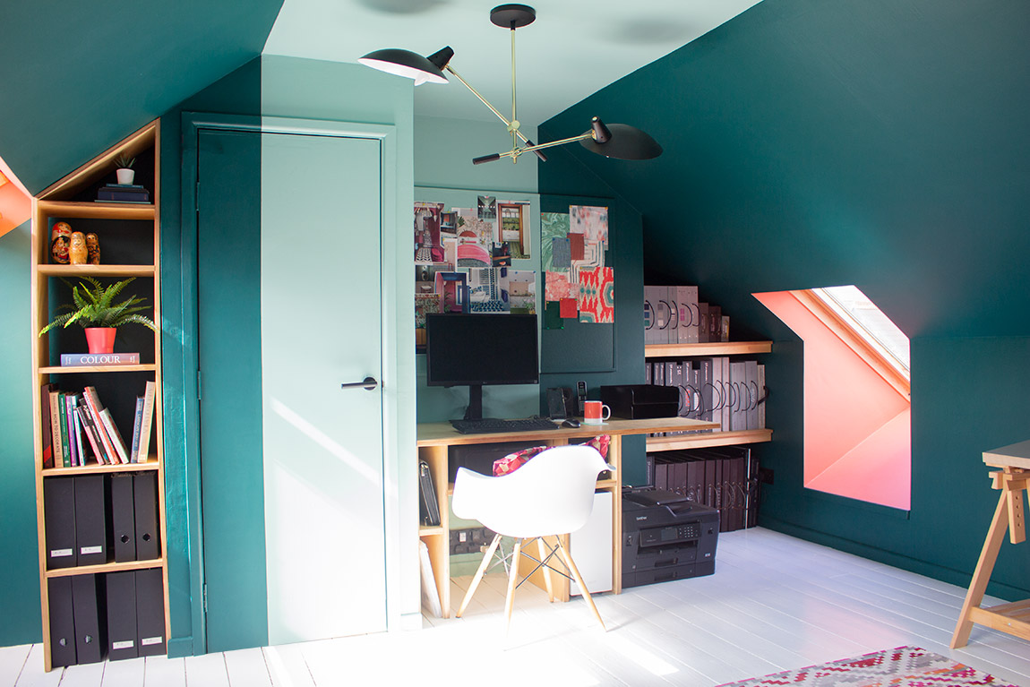 A photo of a colourful colour blocked office in a loft room, painted teal, coral and aquamarine.