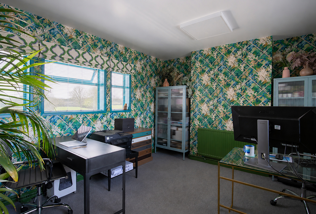 A photo of the larger office, showing the view looking the other way. There are two desks and some mid blue cabinets.