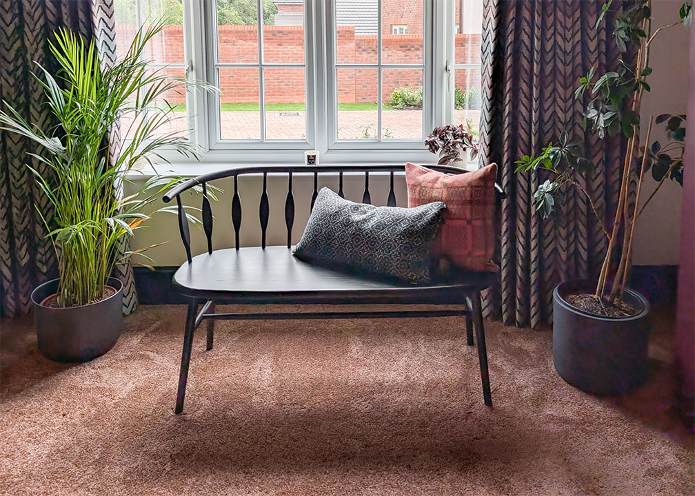 A photo looking at a bench in a living room with a plush deep pile terracotta carpet.