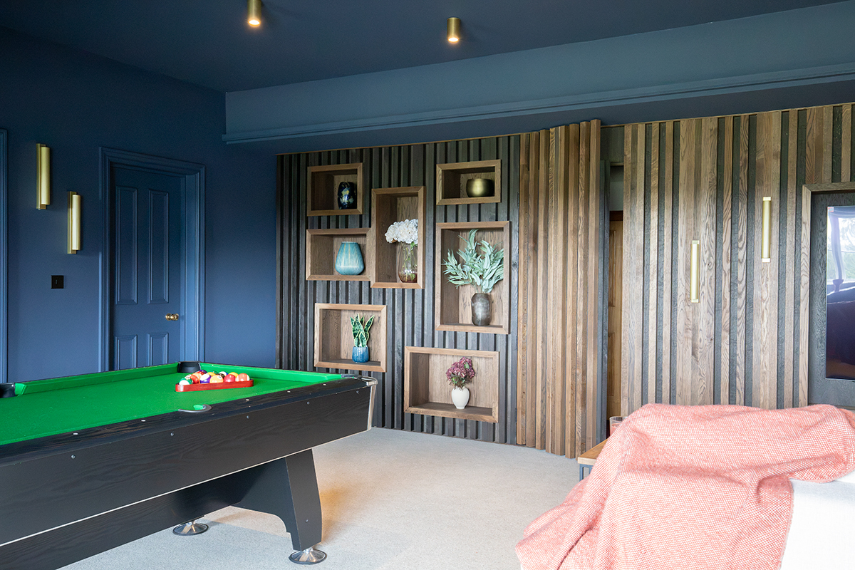 A photo of the media wall in the cinema room, with the hidden slatted door slightly open. You can also see the display niches in the wall.
