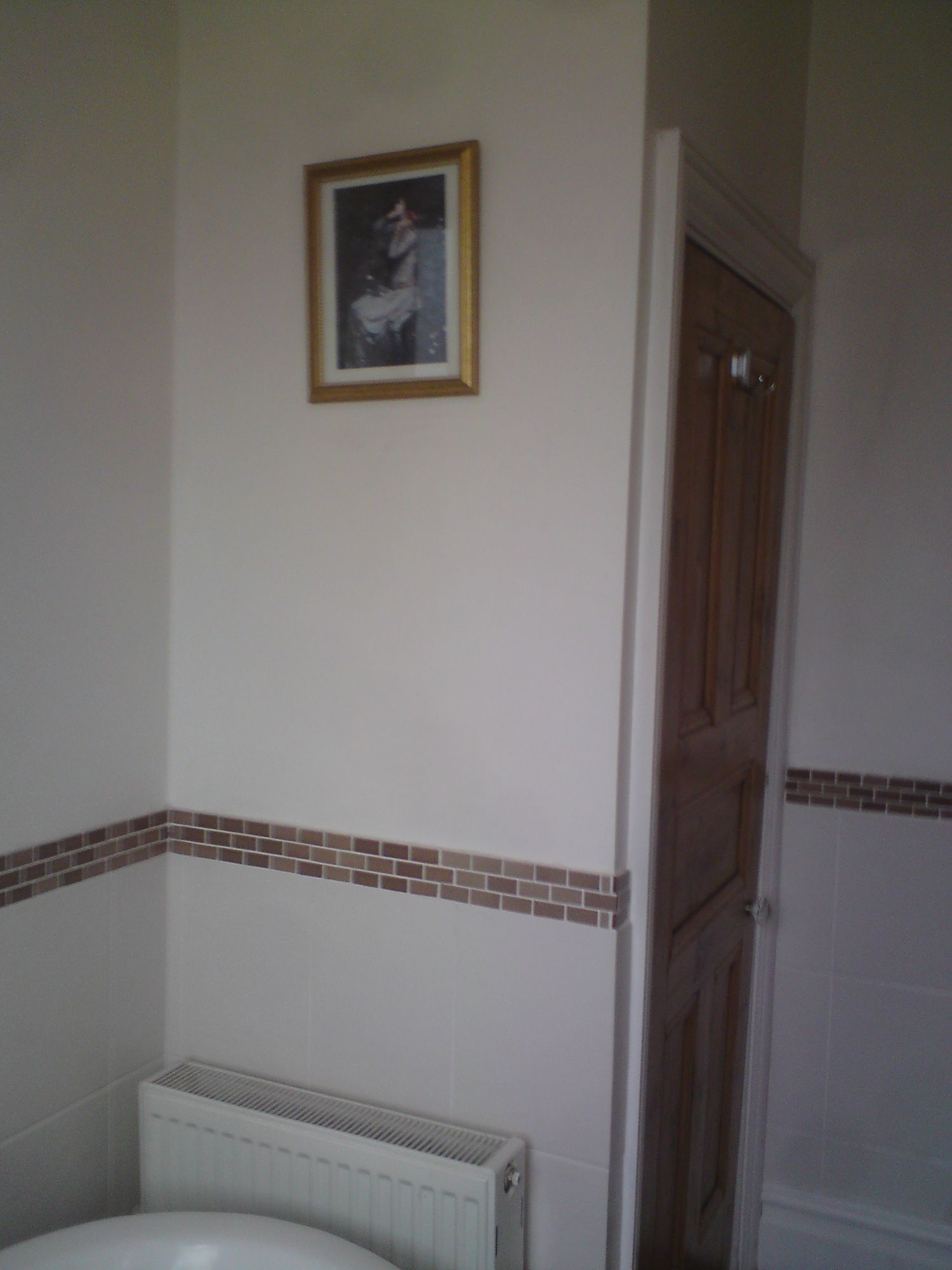 A photo of the airing cupboard door, with a bare wall where the towel radiator was moved to.