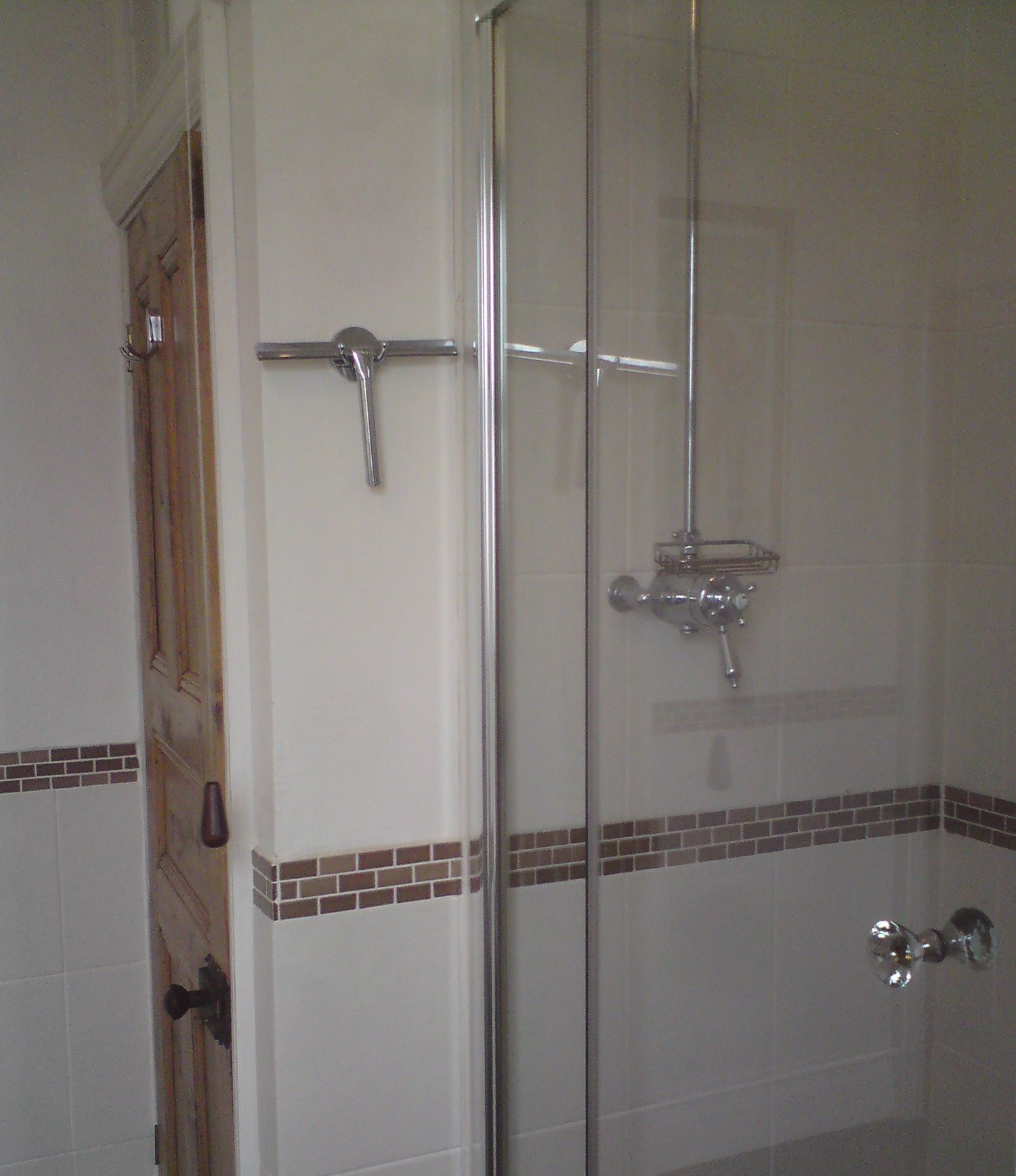 The old glass door to the shower enclosure, showing the smaller shower area.