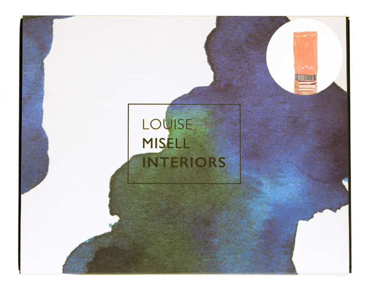 A photo of the outside of the Designer in a Box with a small paintbrush showing a light orange paint colour.