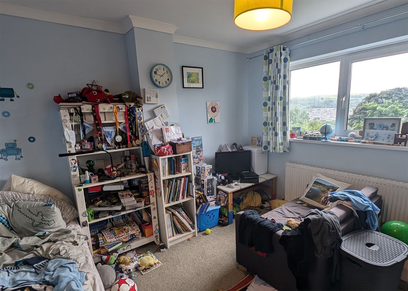 The same view with short curtains at the window, and no wardrobes.