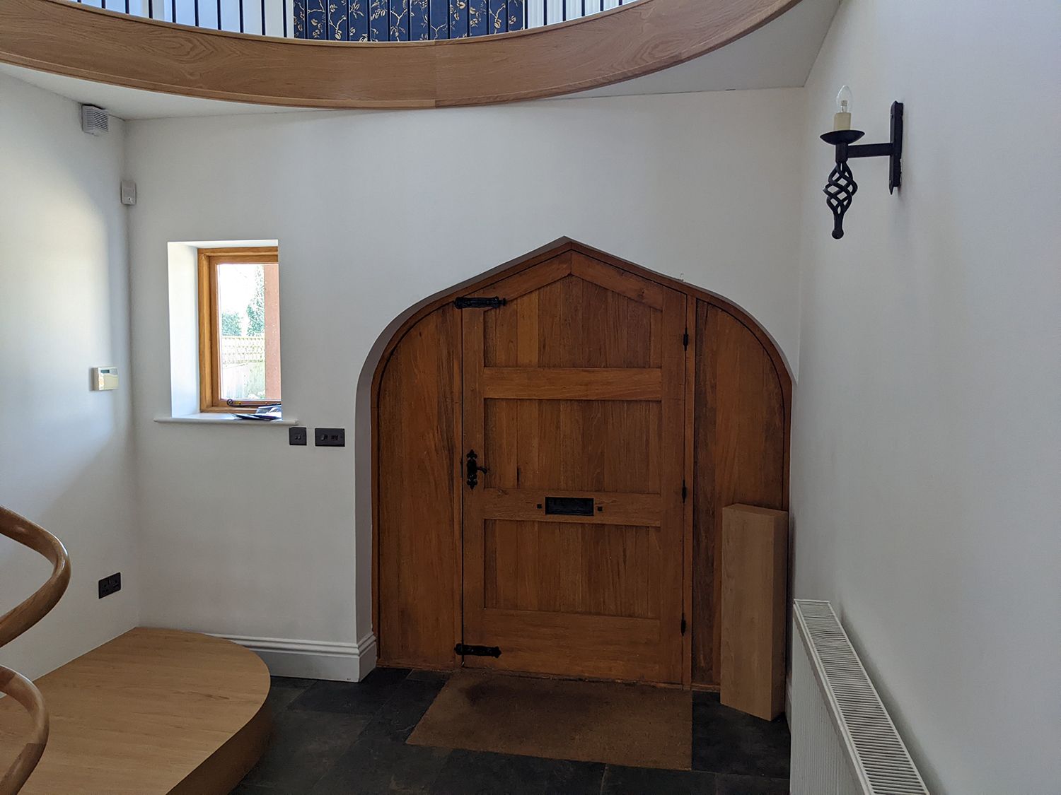 A before photo showing the front door with white walls and no furniture or storage.