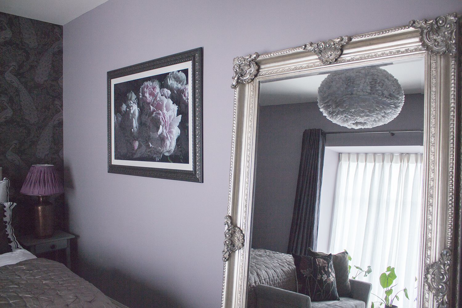 A photo of the ornate leaner mirror against the lilac wall, with the new purple and black floral artwork.