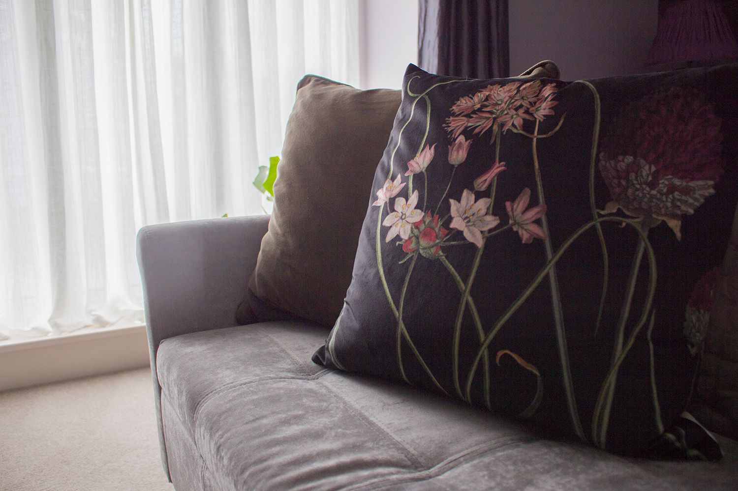 A close up of the new velvet cushions on the upholstered bench with the new sheer curtains behind.