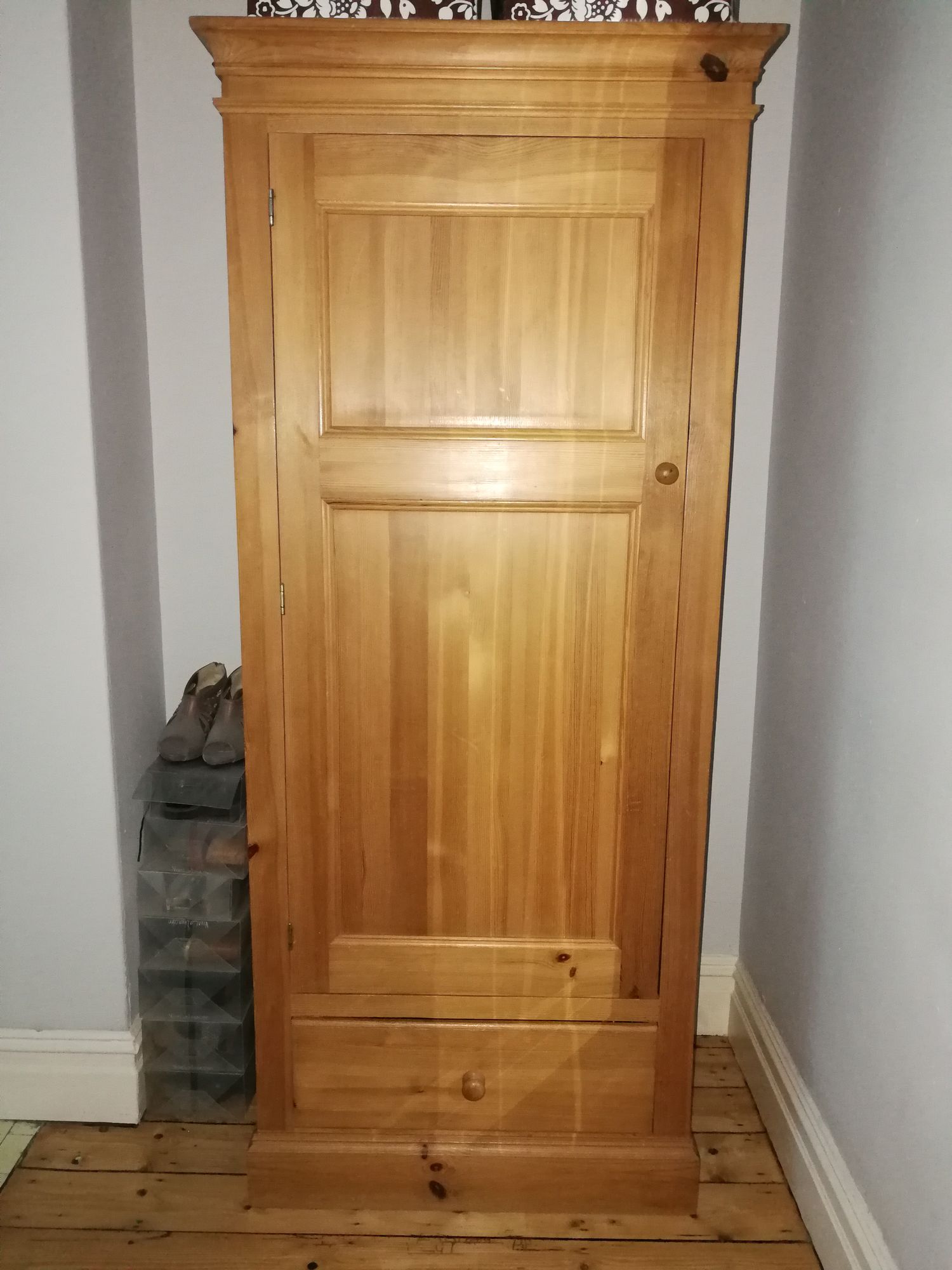 Before, the wardrobe was pine, with brown storage boxes on top.
