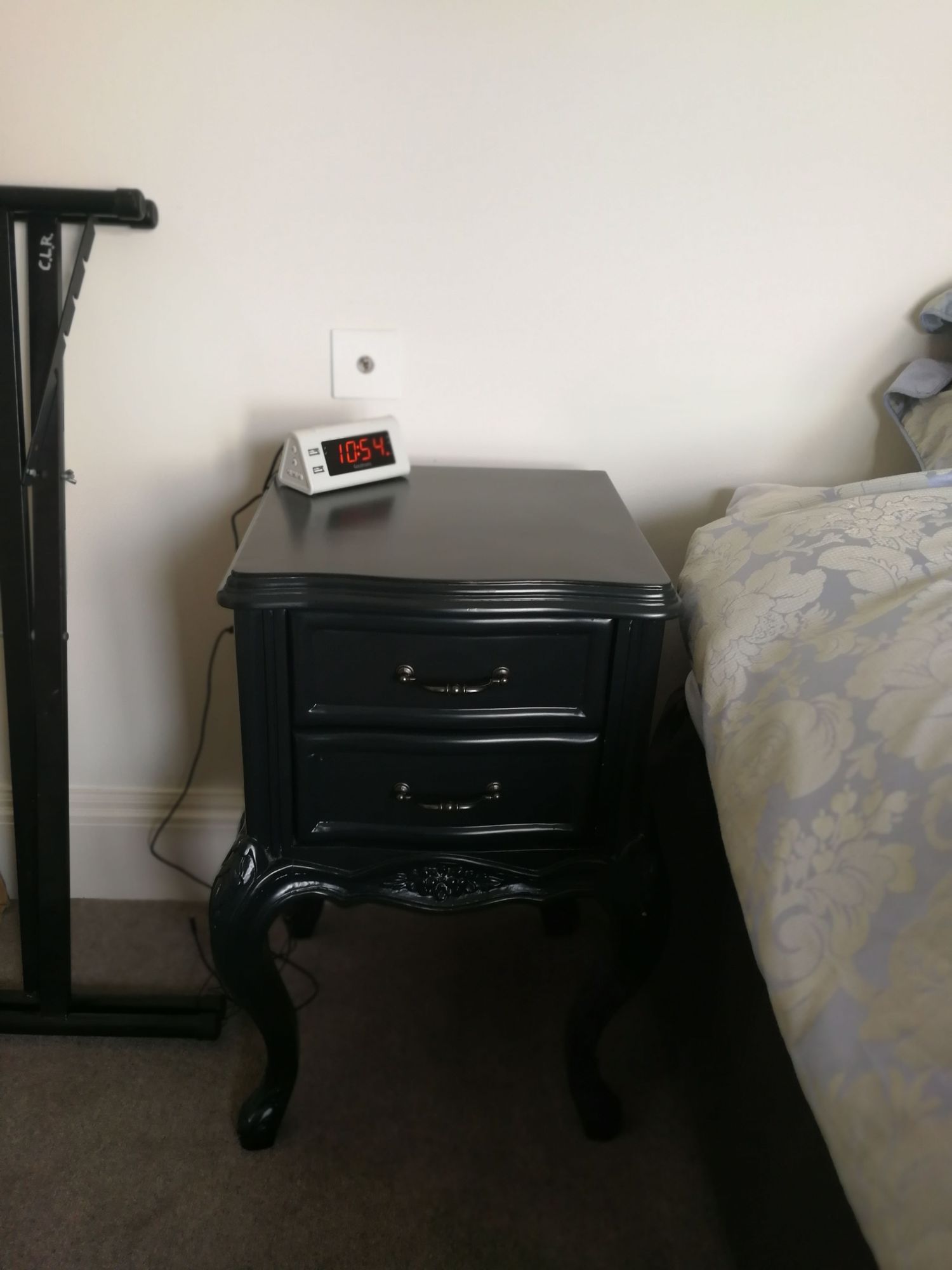 The old bedside table was heavy and black, and had no lamp.