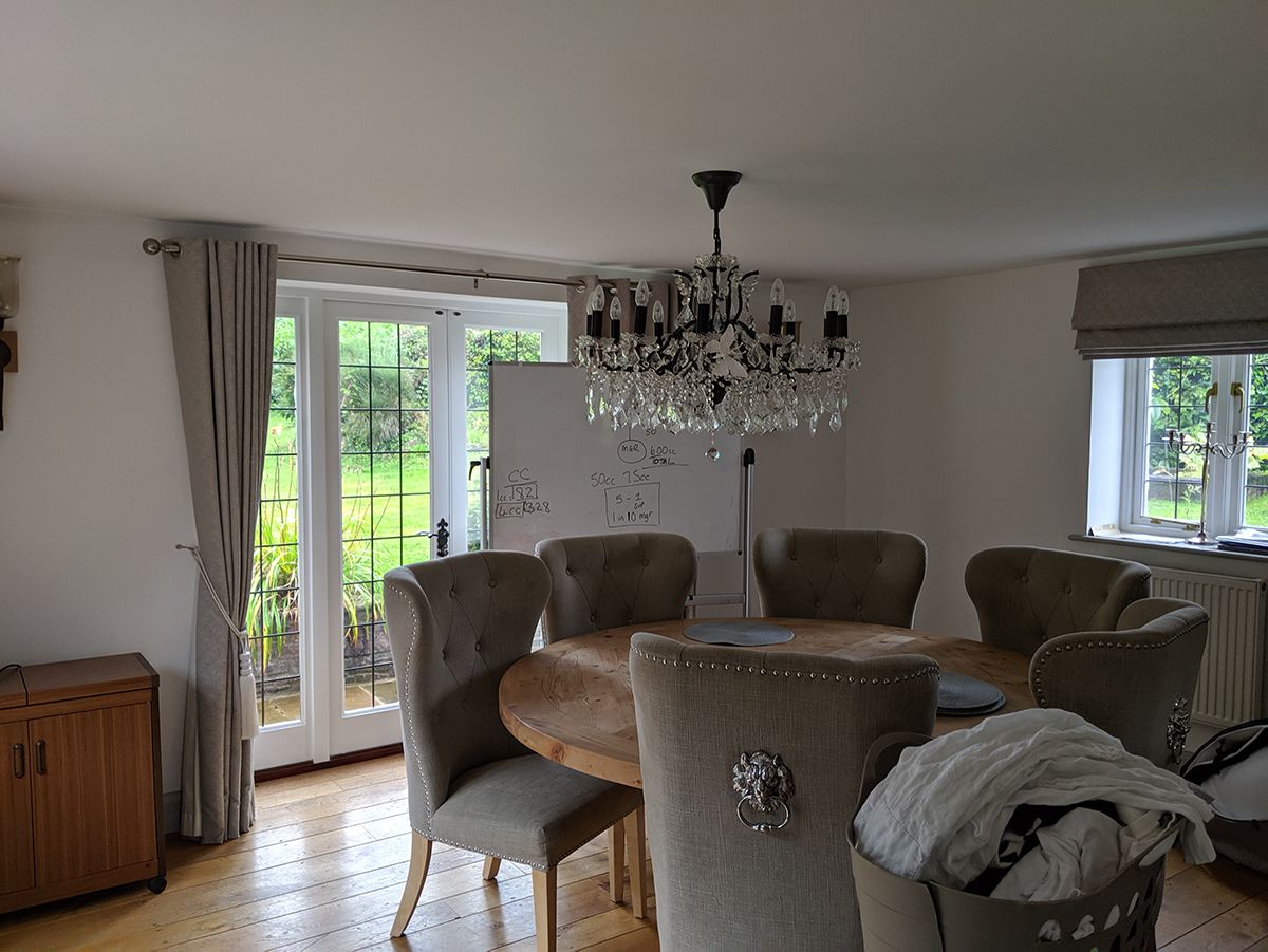 The before photo shows the room as a dining room with a round table and grey upholstered chairs.