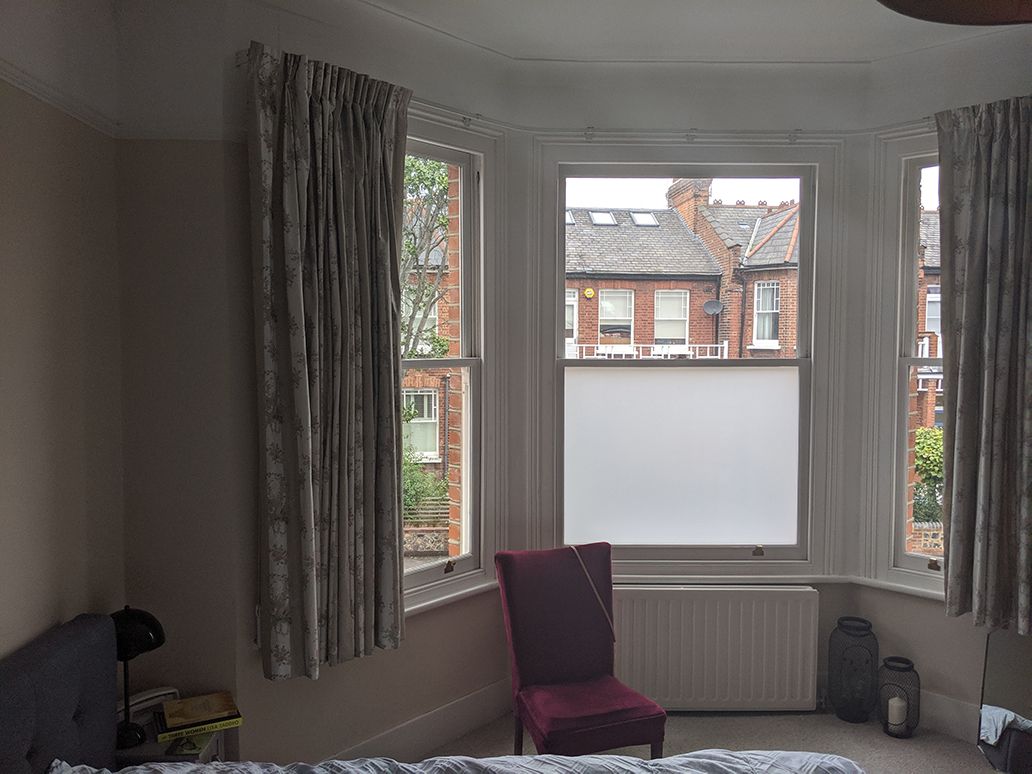 A before photo showing the magnolia walls and floral curtains at the window.