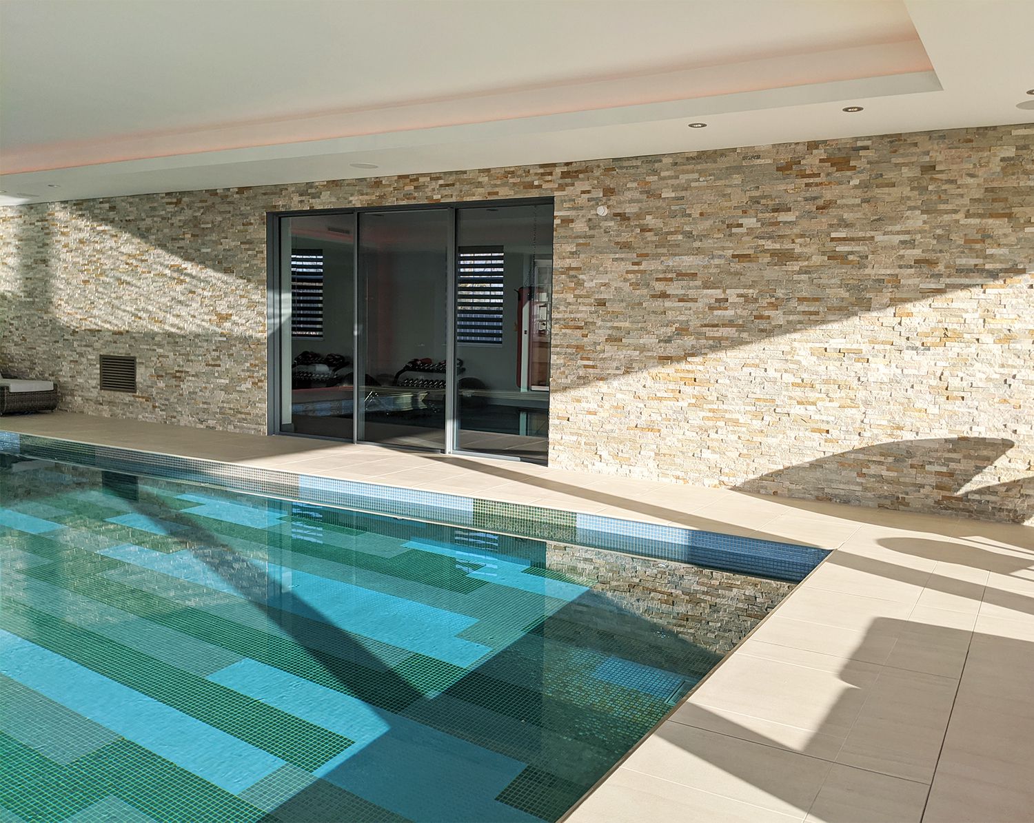 The pool with the glass doors which are the entrance to the gym.