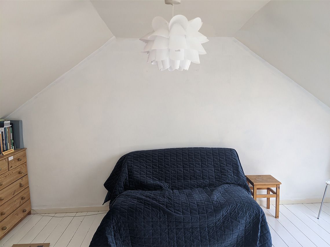 The room before with the unpainted beige walls and the chest of drawers and plant stand before they were painted.