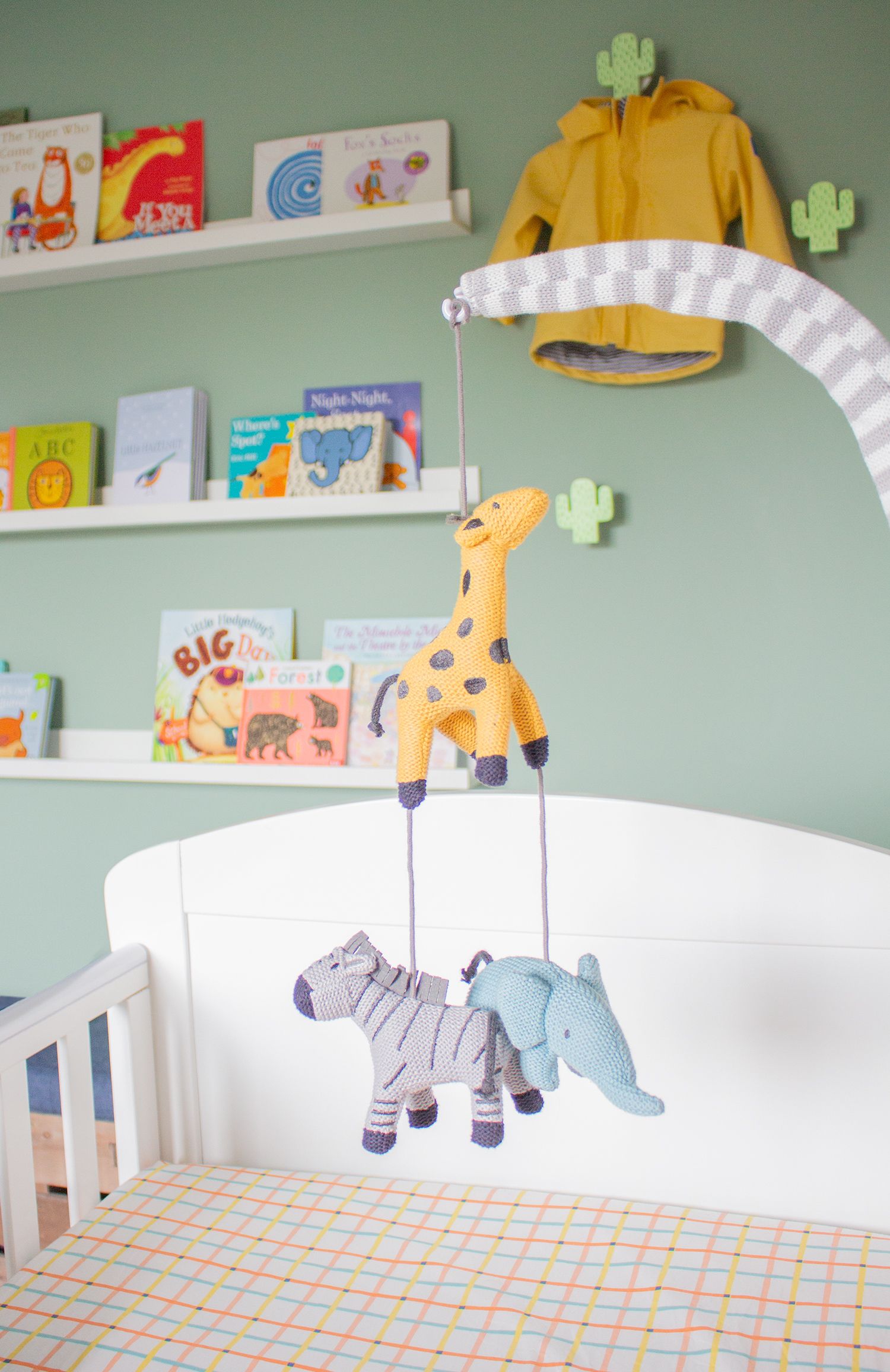 A close up of the soft toy cot mobile which has a giraffe, an elephant and a zebra.