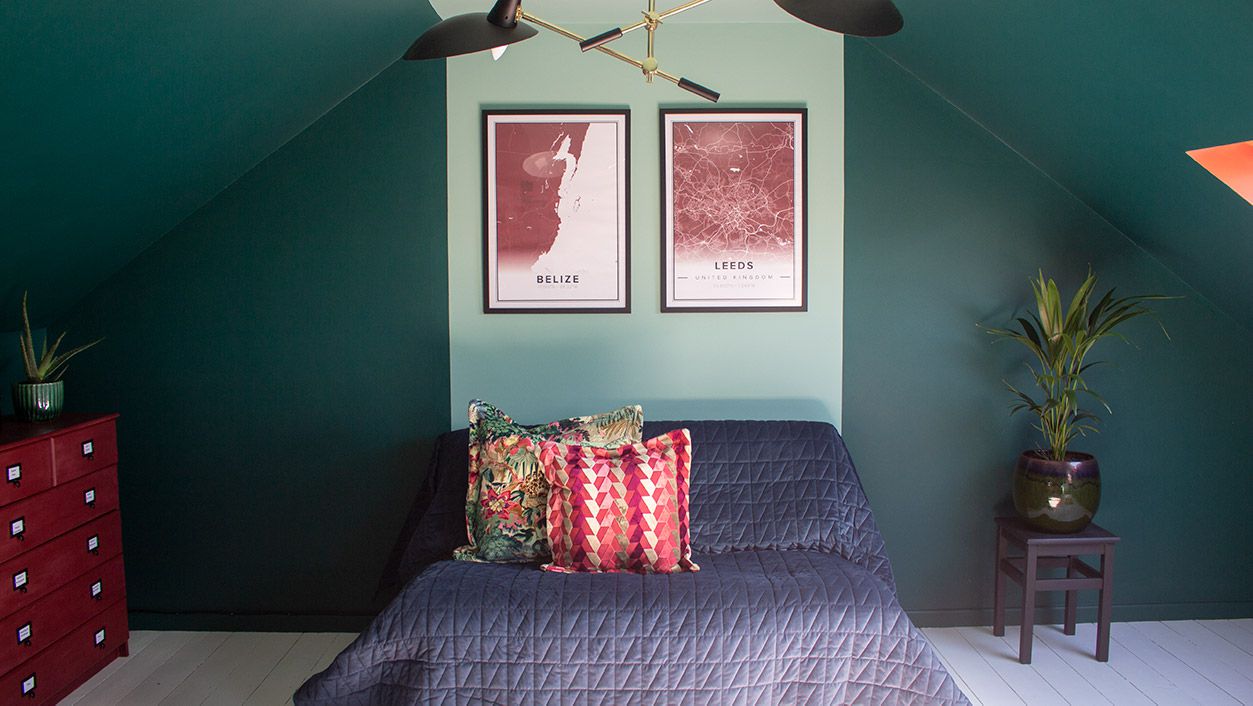 A photo of the loft with dark green walls with a strip of light green down the middle.