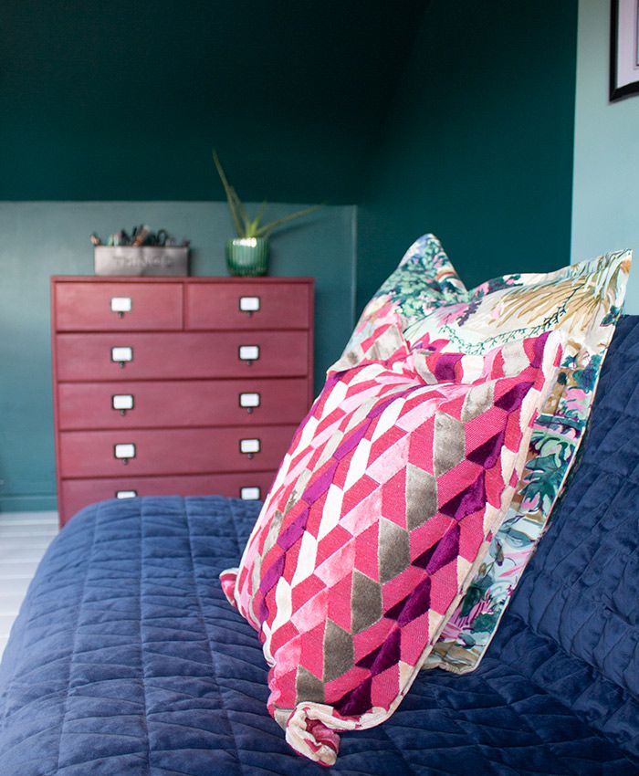 A photo of the patterned cushions on the sofa with the painted chest of drawers in the background.