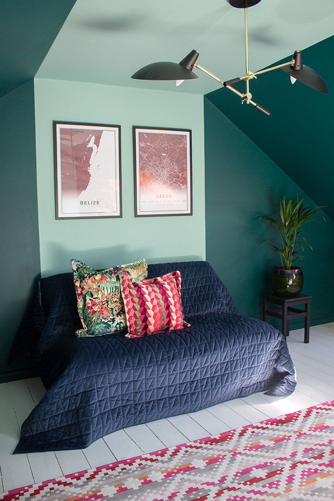 A view of the sofa, with the bright cushions on it and posters above.