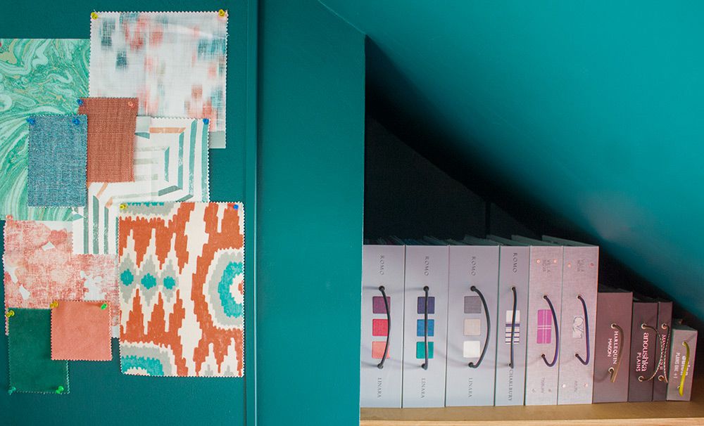 A close up of the plywood shelving holding fabric books, and the painted noticeboard.