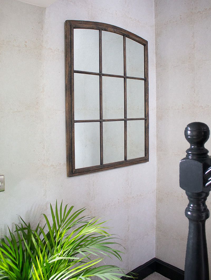 A close up of the industrial style window mirror at the bottom of the stairs.