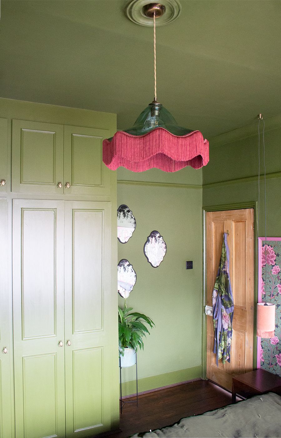 The fringed glass lampshade in the main bedroom, against a backdrop of the Bancha green wardrobes.