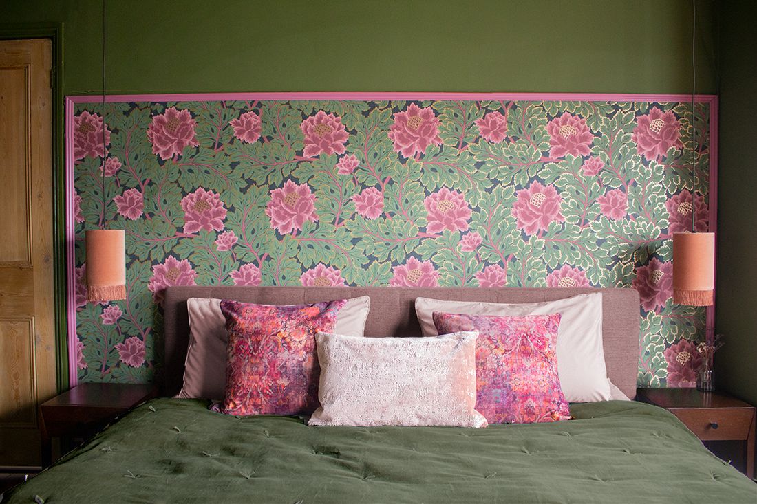 A view of the pink and green floral wallpaper behind the headboard in the main bedroom.