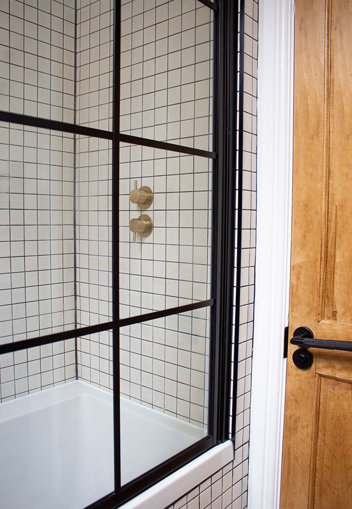 A photo of the Crittall style shower screen, where you can see the brass shower valve through it.