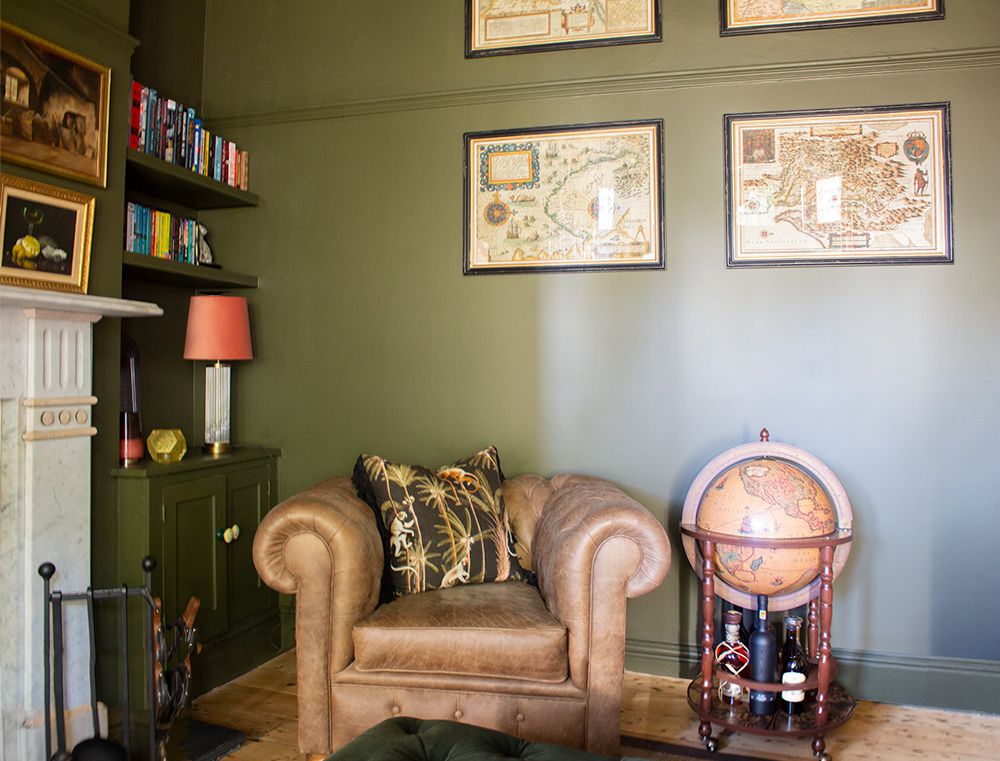 A photo of the leather chesterfield chair with a globe bar in the living room.