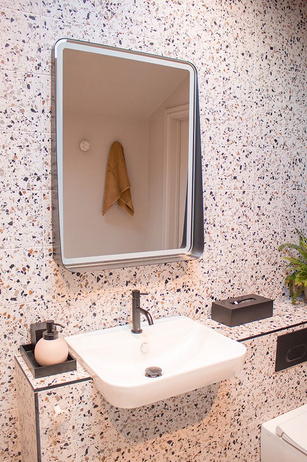 The vanity area in the new wet room, with black edged mirror above.