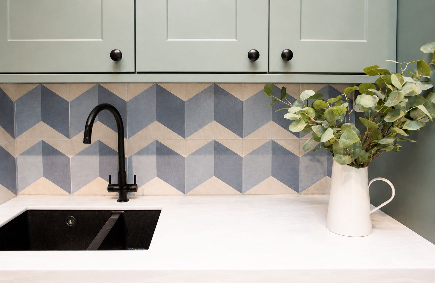 The new utility room with green cabinets and a white Corian worktop.