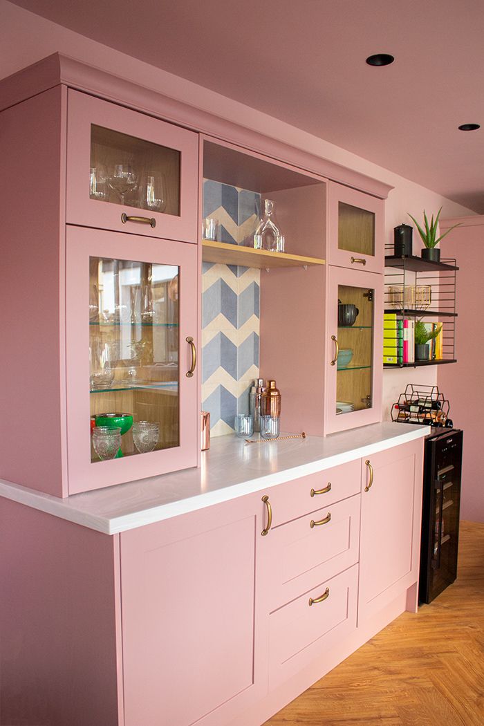 A photo of the new pink kitchen dresser with brass handles and blue tiling at the back.