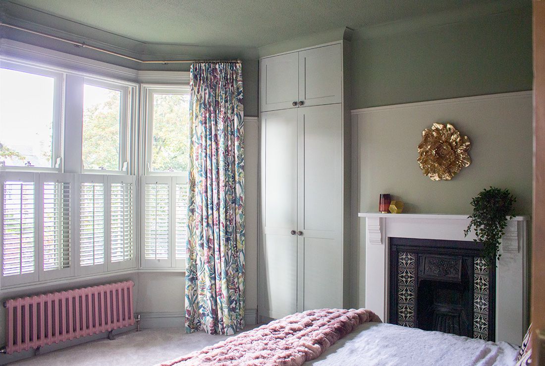 The main bedroom bay window with new curtains, painted shutters and built in wardrobes.