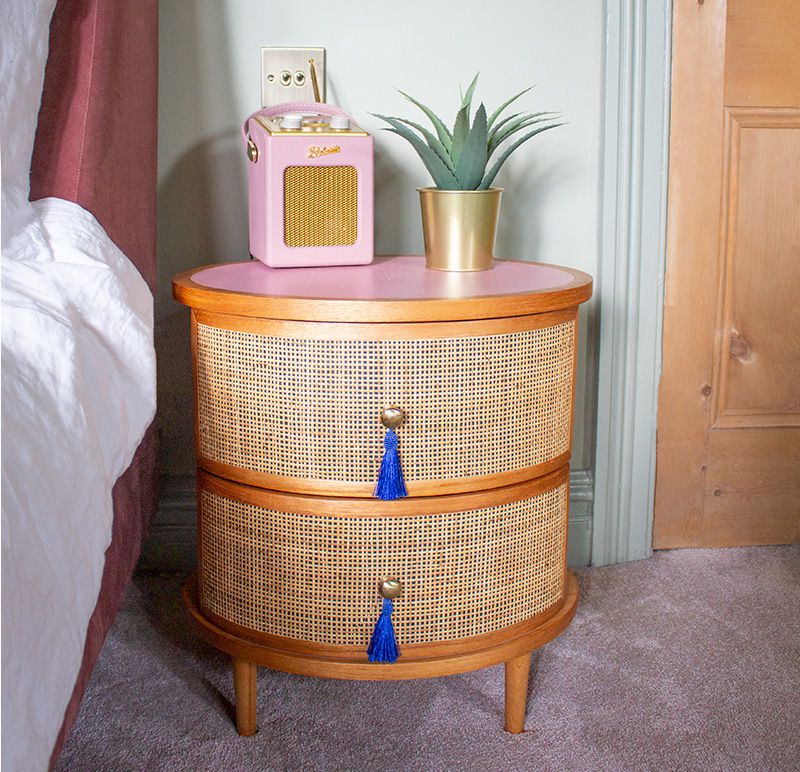 A close up of the rattan and fringed bedside table in the main bedroom.