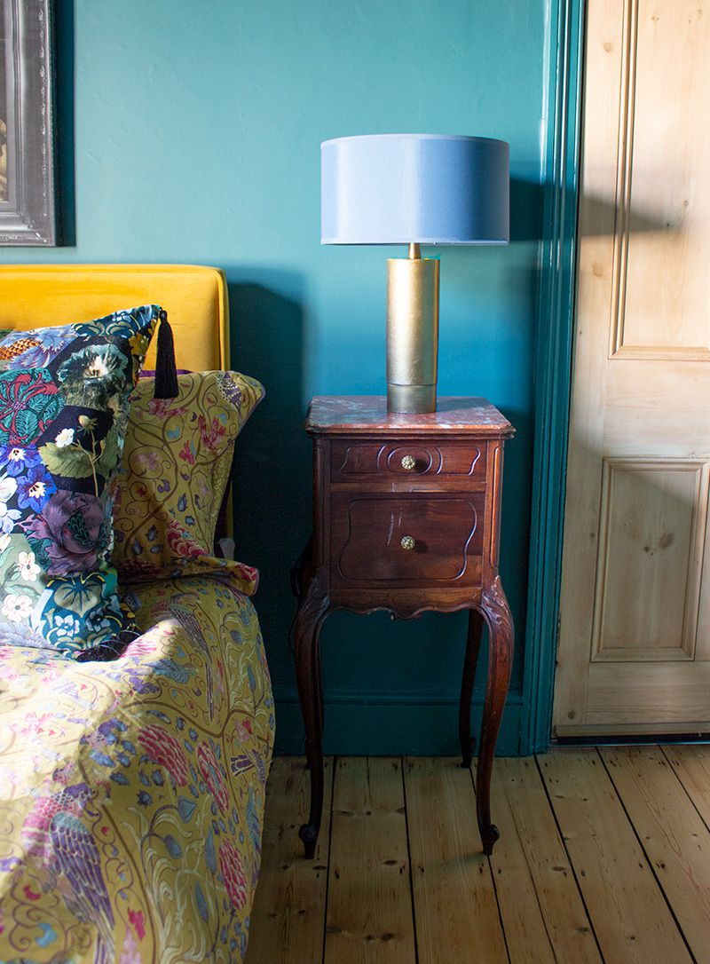 A photo of middle bedroom painted teal and the vintage bedside table.