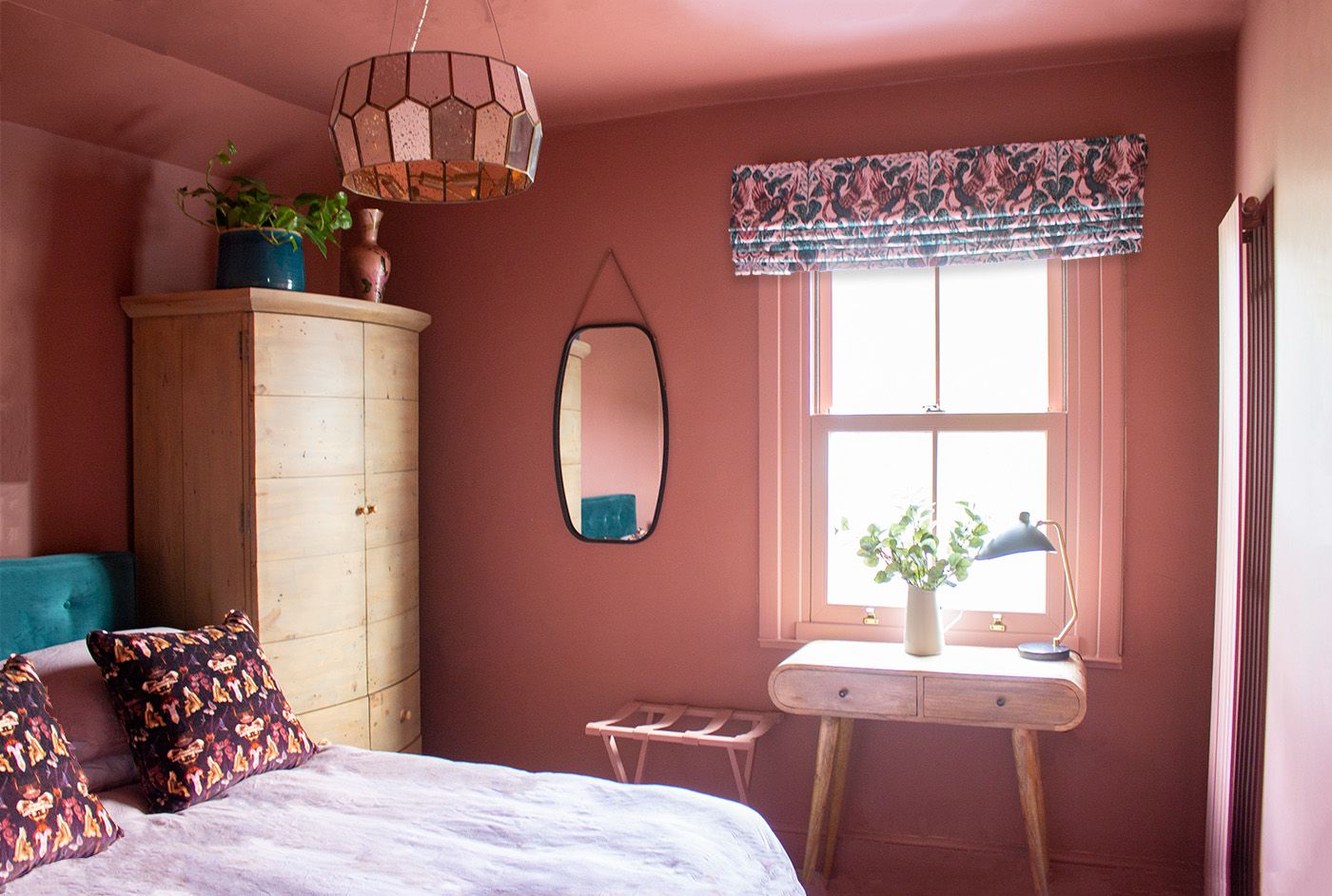 A photo of the new terracotta back guest bedroom, with a colourful Roman blind at the window.