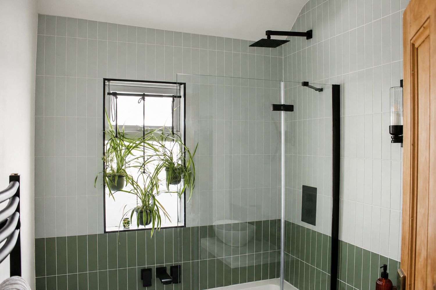 The refreshed main bathroom with new sanitary ware, a vintage dresser as a sink, and green and pink tiling.
