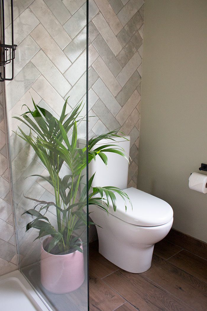 A photo of the new WC in the en suite, which has green herringbone tiles and a pink sink.