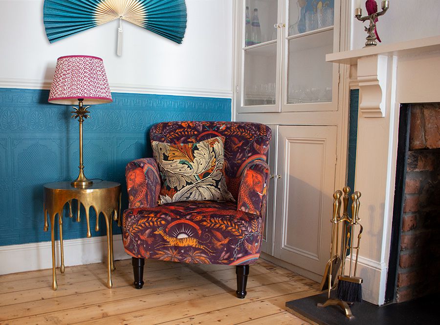 A colourful velvet chair in the teal painted middle reception room.