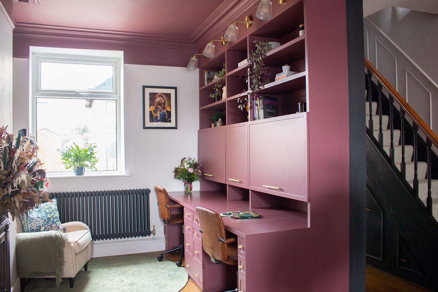 A photo showing the burgundy double desk with period cornicing and doors which hide the computer screens.