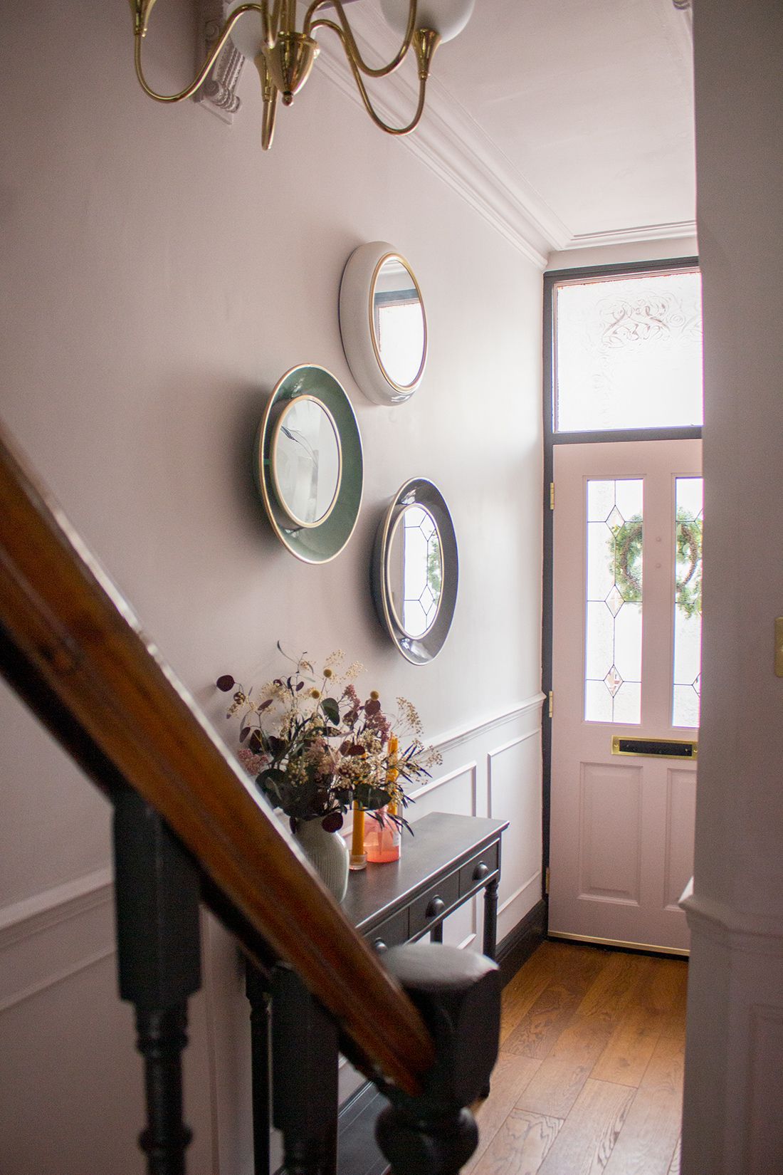 A photo of the hallway looking towards the front door, showing the charcoal grey and pink colour scheme.