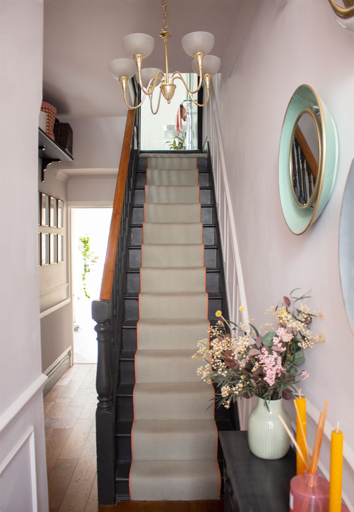 A photo of the hallway leading to the desk area, showing the charcoal painted stairs and cream runner.